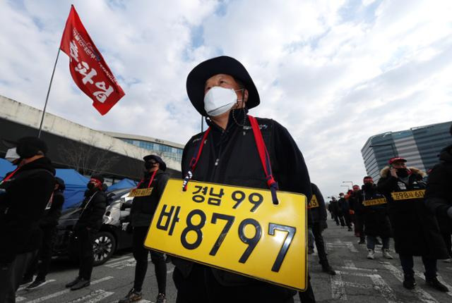 안전운임제 일몰제 폐지 및 확대를 요구하며 총파업에 나섰던 민주노총 공공운수노조 화물연대본부(화물연대) 관계자들이 2022년 12월 세종시 정부세종청사 국토교통부 앞에서 집회를 연 뒤 행진하고 있다. 노란색 '화물 운송용 번호판'은 지입료 갑질의 상징이다. 연합뉴스