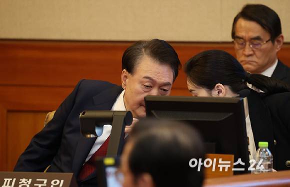 윤석열 대통령이 13일 오전 서울 종로구 헌법재판소에서 열린 탄핵심판 8차 변론에 출석해 변호인과 이야기를 하고 있다. [사진=사진공동취재단]