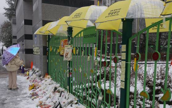 12일 대전 초등학생 피살사건이 발생한 대전 서구의 한 초등학교 정문에 추모객들이 놓고 간 국화과 편지 위에 우산이 설치돼 있다. 뉴스1