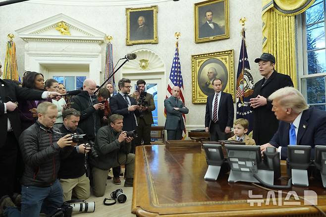 [워싱턴=AP/뉴시스] 미국 정부효율부(DOGE) 수장인 일론 머스크 테슬라 최고경영자(CEO)가 11일(현지 시간) 백악관 집무실에서 도널드 트럼프 대통령이 지켜보는 가운데 언론 브리핑하고 있다. 2025.02.12.