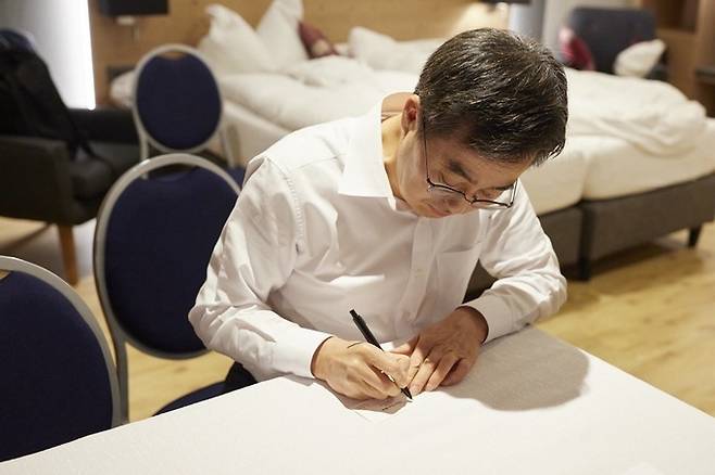 김동연 경기도지사가 스위스 다보스의 숙소에서 명함에 ‘Trust in korea’라는 문구를 쓰고 있다. 경기도 제공