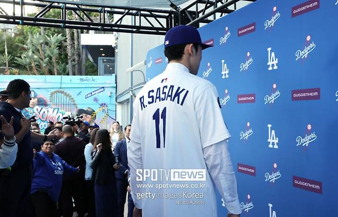 ▲ LA 다저스에 입단한 일본인 우완투수 사사키 로키가 등번호 11번이 새겨진 자신의 유니폼을 공개하고 있다.