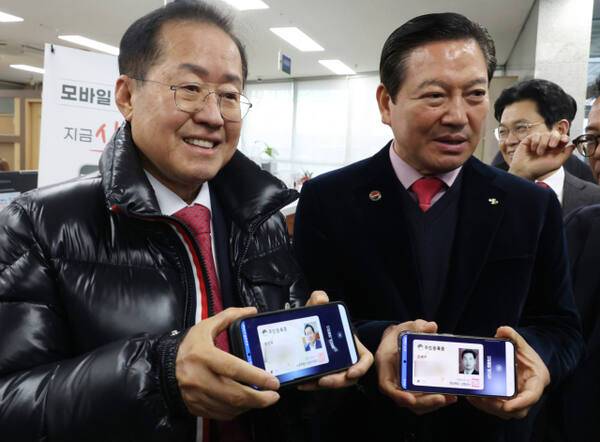 홍준표 대구시장이 모바일 주민등록증 발급 시작일인 14일 대구 남구 봉덕2동 행정복지센터에서 모바일 주민등록증을 발급받은 뒤 조재구 남구청장과 기념 촬영을 하고 있다. 연합뉴스