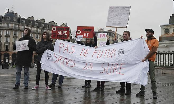프랑스 파리에서 지난 10일(현지시간) 열린 인공지능 회의장 부근에서 시민들이 ‘안전한 AI 없이 미래는 없다’는 구호를 적어 피켓시위를 하고 있다. AP연합뉴스