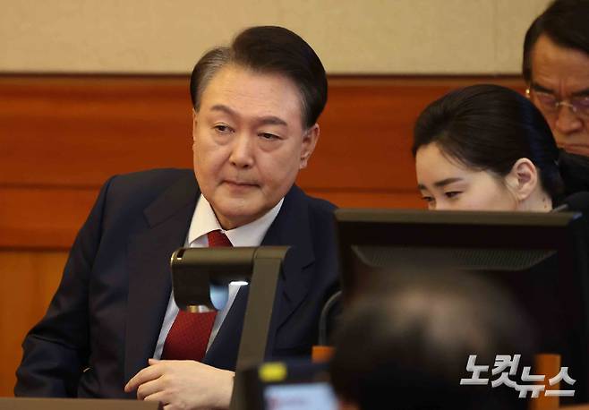 윤석열 대통령이 13일 오전 서울 종로구 헌법재판소에서 열린 탄핵심판 8차 변론에 출석해 변호인과 이야기를 하고 있다. 사진공동취재단