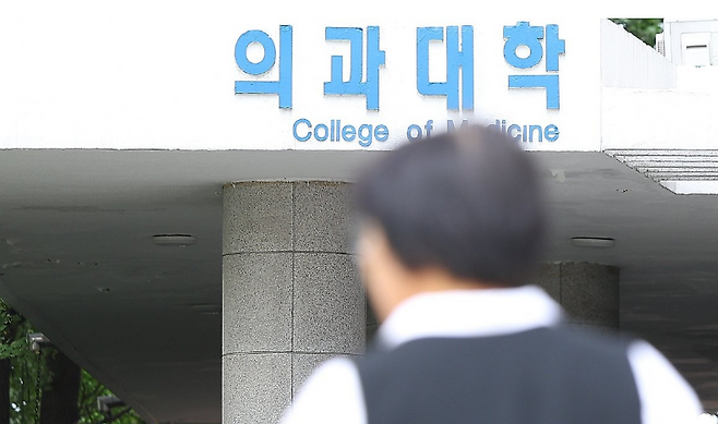 22일 오전 서울 시내 한 의과대학에서 한 시민이 의과대학 간판을 지나치고 있다. 연합뉴스