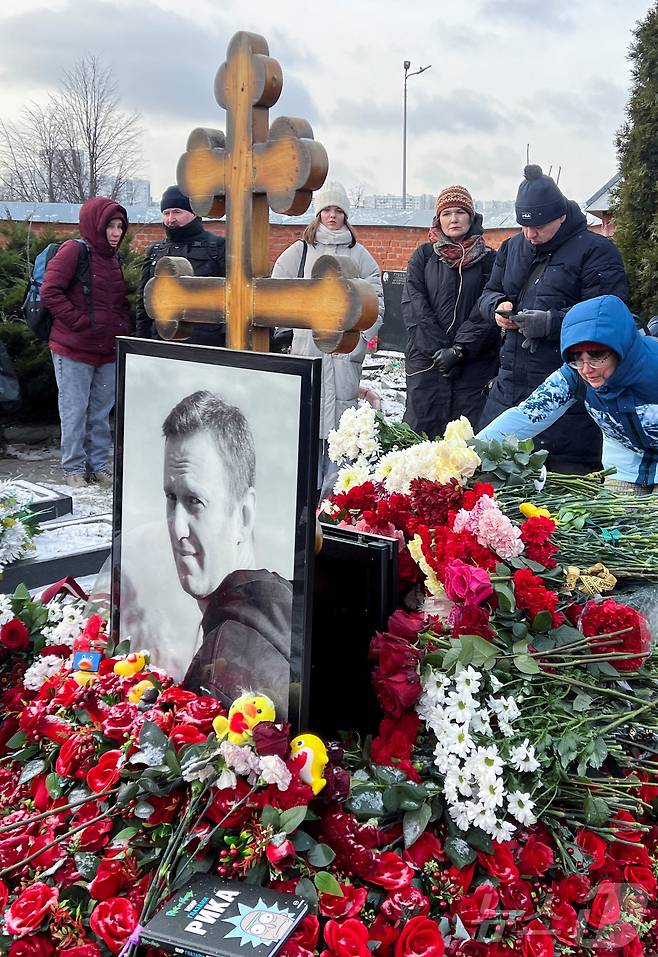 16일(현지시간) 러시아 모스크바 보리솝스코예 묘지에 있는 알렉세이 나발니의 묘지에서 시민들이 나발니 사망1주기를 추모하고 있다. ⓒ 로이터=뉴스1