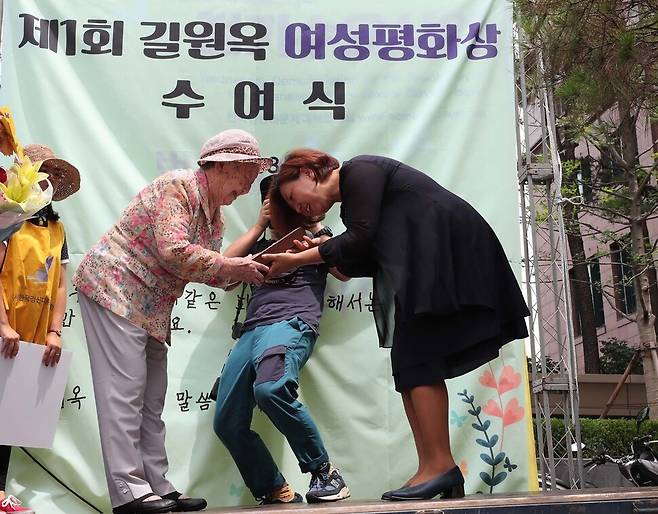 길원옥 할머니(왼쪽)가 2017년 8월2일 서울 종로구 옛 일본대사관 앞에서 열린 ‘제1294차 일본군성노예제 문제해결을 위한 정기 수요시위’에서 베트남 평화활동가 구수정씨에게 제1회 길원옥 여성평화상을 전달하고 있다. 백소아 기자 thanks@hani.co.kr