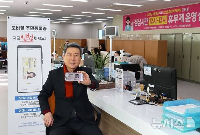 [포항=뉴시스] 송종욱 기자 = 이강덕 포항시장은 17일 임시 청사인 오천읍행정복지센터에서 QR 코드 방법으로 모바일 주민등록증을 발급 받은 후 임시 청사 운영 상황을 점검하고 민원인 불편 사항을 살폈다. 사진은 이 시장이 모바일 주민등록증을 발급 받은 후 손으로 들어 보이는 모습. (사진=포항시 제공) 2025.02.17. photo@newsis.com