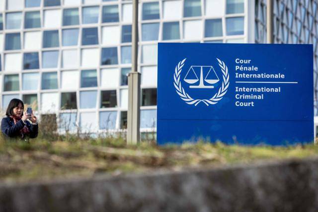 한 여성이 지난해 11월 21일 네덜란드 헤이그의 국제형사재판소(ICC) 앞에 설치된 ICC 로고를 촬영하고 있다. 헤이그=ANP·AFP 연합뉴스