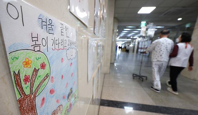 의정 갈등이 계속되며 전공의 이탈 상황이 1년째 지속하고 있는 지난 3일 대구 한 대학병원에 붙은 글귀 옆으로 환자가 지나가고 있다. 연합뉴스