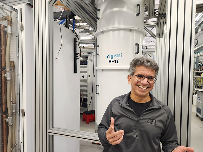 수보드 쿨카르니 리게티컴퓨팅 CEO가 양자 컴퓨터 앞에서 미소를 짓고 있다. [이덕주 기자]