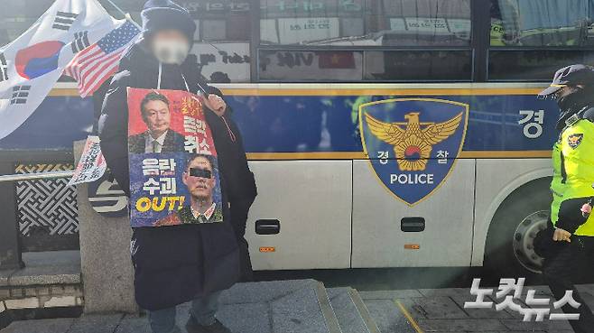 18일 서울 종로구 안국역에서 윤석열 대통령 탄핵을 반대하는 1인 시위를 진행하고 있는 한 남성이 문형배 헌법재판소장 권한대행을 겨냥한 문구가 적힌 포스터를 목에 걸고 있다. 주보배 기자