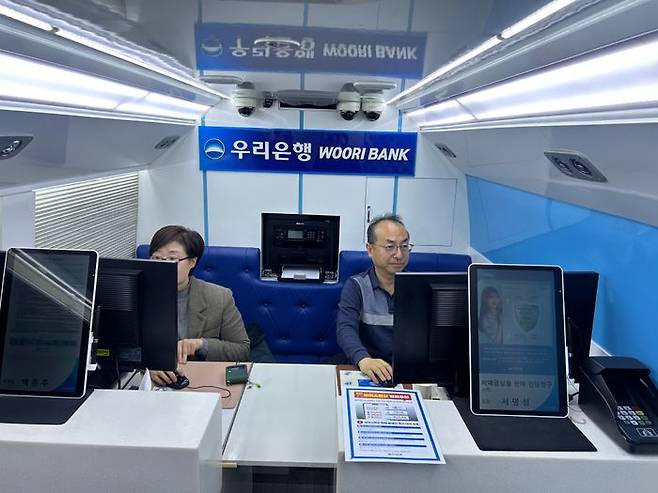 백은주(왼쪽) 본점영업부 부부장과 서명성 본점영업부 부부장이 이동점포에서 업무를 보고 있다.ⓒ정지수 기자