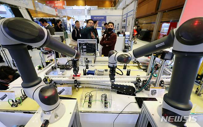 [서울=뉴시스] 조성우 기자 = 27일 오후 서울 강남구 코엑스에서 열린 2024 스마트공장·자동화산업전을 찾은 관람객들이 레인보우로보틱스의 협동로봇을 살펴보고 있다. 2024.03.27. xconfind@newsis.com