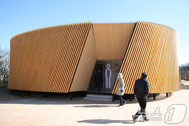 대구 수성구 수성못 상화동산 공중화장실이 최근 리모델링 공사를 마치고 개방됐다. 스페인 건축가의 설계를 바탕으로 예술적 요소를 강조한 이 화장실 리모델링 공사에 수성구가 예산 9억 원을 투입한 사실이 알려지며 논란이 일고 있다. 20일 수성못을 찾은 시민들이 화장실을 이용하고 있다. 2025.2.20/뉴스1 ⓒ News1 공정식 기자