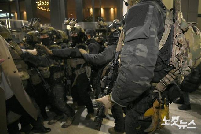 윤석열 대통령이 지난해 12월 3일 밤 비상계엄을 선포한 가운데 4일 새벽 서울 여의도 국회에서 경내로 진입하려는 계엄군과 저지하려는 시민 및 국회 관계자들이 대치하고 있다. 박종민기자