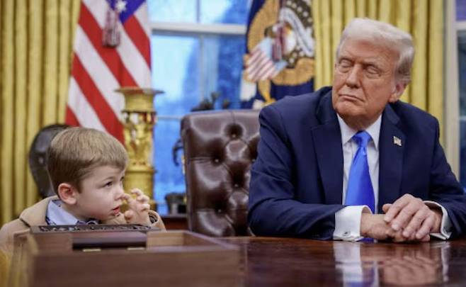 지난 11일(현지시각) 미국 워싱턴 DC 백악관 집무실 결단의 책상 앞에 도널드 트럼프 미국 대통령(오른쪽)과 일론 머스크의 아들인 엑스 머스크가 앉아 있는 모습. 사진=연합뉴스