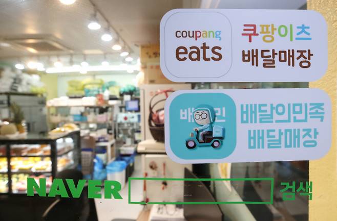 배달플랫폼-입점업체 상생협의체가 협의한 차등 수수료 시행이 임박했다. 배달의민족은 오는 26일부터, 쿠팡이츠는 4월1일부터 적용한다. 협의안에 따라 수수료율 적용 구간과 배달비 등은 같지만 정산 구조 등 세부 내용은 차이가 있다. 플랫폼사들은 각각 자사의 정책 알리기에 나섰다. 중개수수료 인하 상생방안을 마련했다. 서울시내 한 음식점에 붙어있는 배달의민족과 쿠팡이츠 스티커. /사진=뉴스1