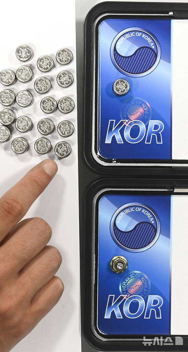 [수원=뉴시스] 김종택 기자 = 자동차 등록번호판 봉인제도 폐지를 하루 앞둔 20일 경기도 수원도시공사 번호판제작소에서 관계자가 기존 스테인리스 마개로 봉인된 번호판(사진 위)과 마개를 제거한 뒤 너트로 고정한 번호판을 보여주고 있다.도난, 번호판 위·변조 방지를 위해 1962년 시행된 자동차 등록번호판 봉인제도는 자동차관리법 일부 개정에 따라 등록번호판에 봉인을 부착하지 않고 운행할 수 있다. (공동취재) 2025.02.20. photo@newsis.com