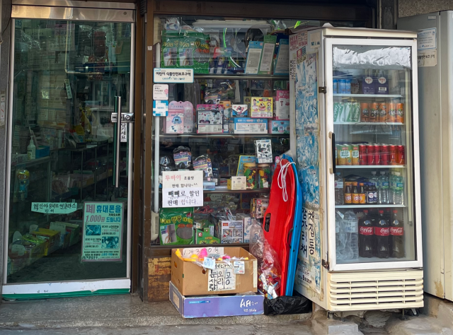 20일 서울 은평구 응암동 한 문구점 앞에 ‘빼빼로 할인판매’ ‘폐 휴대폰 1000원에 드립니다’ 등 문구가 덕지덕지 붙어 있다. 장문항 견습기자