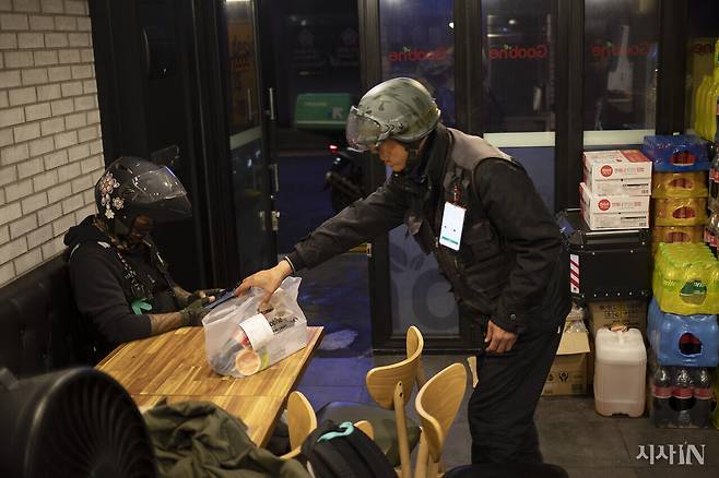 치킨집에서 자신이 배달해야 할 음식을 기다리는 배달 노동자들. ⓒ시사IN 이명익