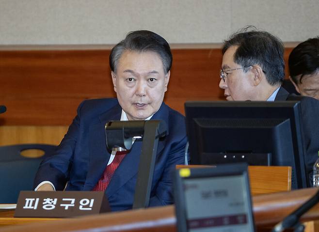20일 오후 서울 종로구 헌법재판소 대심판정에서 윤석열대통령의 탄핵심판 10차 변론이 열린 가운데 자리에 앉은 윤대통령이 변호인과 대화하고 있다. 사진공동취재단