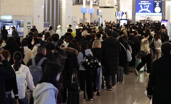 Passengers queue at Incheon Airport, west of Seoul, Jan. 26. (Yonhap)
