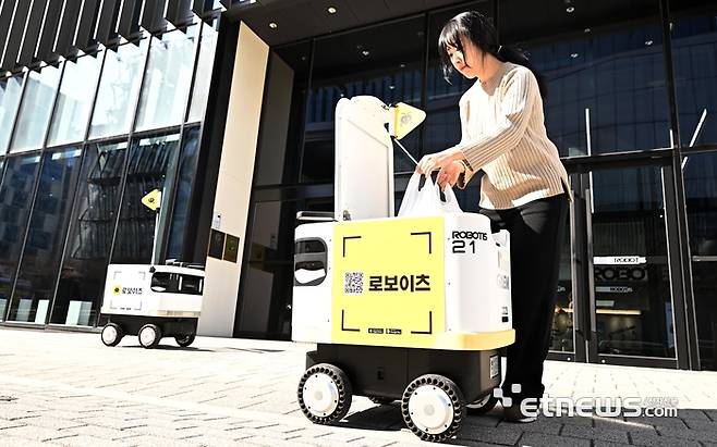 서울 강서구 마곡동 일대에서 한 직장인이 로보티즈의 배달 서비스 '로보이츠'를 이용해 주문한 음식을 수령하고 있다.  이동근기자 foto@etnews.com