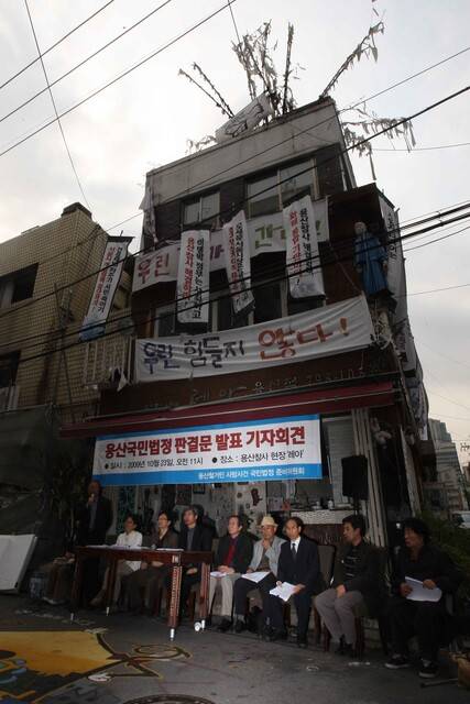 ‘용산 철거민 사망 사건 국민법정 준비위원회’의 조희주 위원(마이크 잡은 이) 등이 2009년 10월23일 오전 서울 용산구 한강로2가 용산 참사 현장 인근에서, 같은 달 18일 열린 국민법정의 판결문을 발표하고 있다. ‘시민 배심원단’은 이명박 대통령과 용산 참사 관련 책임자 20명에게 유죄를 평결했으며, 준비위는 철거민과 유족을 위한 사죄와 손해배상을 촉구했다. 김태형 기자 xogud555@hani.co.kr