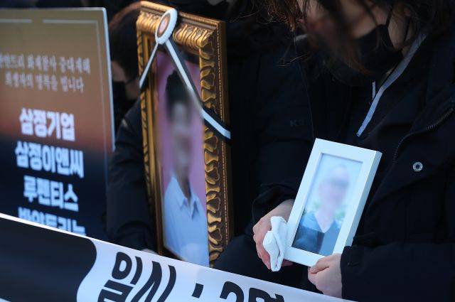 22일 부산 기장군 반얀트리 리조트 화재현장에서 열린 유가족 요구안 발표 기자회견에서 유가족들이 영정사진을 들고 있다. 연합뉴스