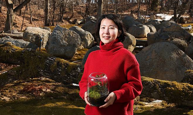 임미려 디엠지숲 대표가 지난 19일 경기 파주 민통선 내 정원에서 이끼가 든 유리병을 들고 포즈를 취하고 있다. 파주=최상수 기자