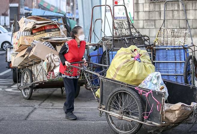 서울 시내 한 폐기물 처리 업체 앞에서 리어카를 끌고 있는 고령의 시민. [사진 | 뉴시스]