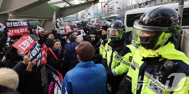 지난 21일 서울 종로구 헌법재판소 인근에서 열린 윤 대통령 지지자들의 탄핵 반대 집회에서 만일의 사태에 대비해 신체보호복을 착용한 경찰들이 경계근무를 서고 있다. 2025.1.21/뉴스1 ⓒ News1 박지혜 기자