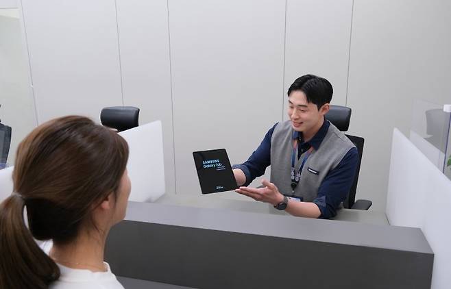 삼성전자서비스 엔지니어가 고객에게 제품 수리와 관련된 설명을 하고 있다. 삼성전자서비스 제공