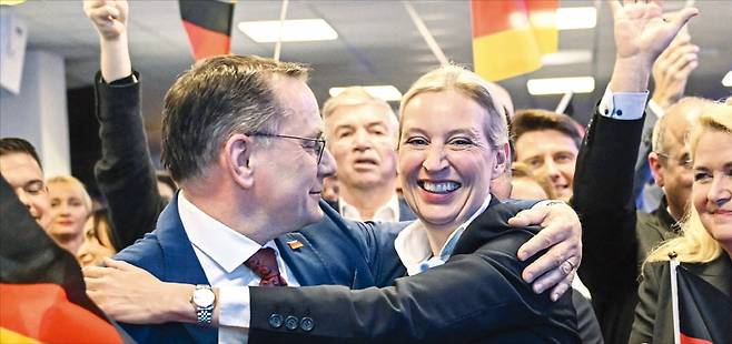 < 제2당 차지한 獨 극우당 > 독일 극우 정당 ‘독일을 위한 대안’의 공동 대표인 알리스 바이델(가운데)과 티노 크루팔라가 23일(현지시간) 베를린 당사에서 총선 출구조사 결과를 확인한 뒤 얼싸안고 있다. 독일대안당은 이날 출구조사에서 역대 최고 득표율인 20.8%를 기록하며 2위를 차지했다.   AFP연합뉴스