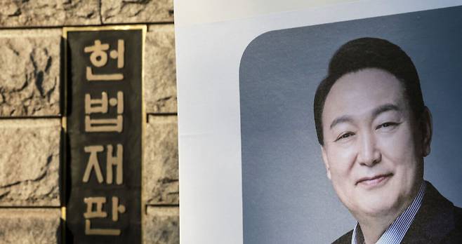 윤석열 대통령의 탄핵심판 최종 변론기일인 25일 서울 종로구 헌법재판소에서 한 지지자가 윤 대통령 사진을 들고 있다. 뉴시스