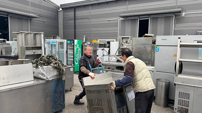 지난 6일 오후 창고 관리인 안태복(왼쪽)씨가 창고 앞에서 싱크대를 받아 나르고 있다. /김도균 기자