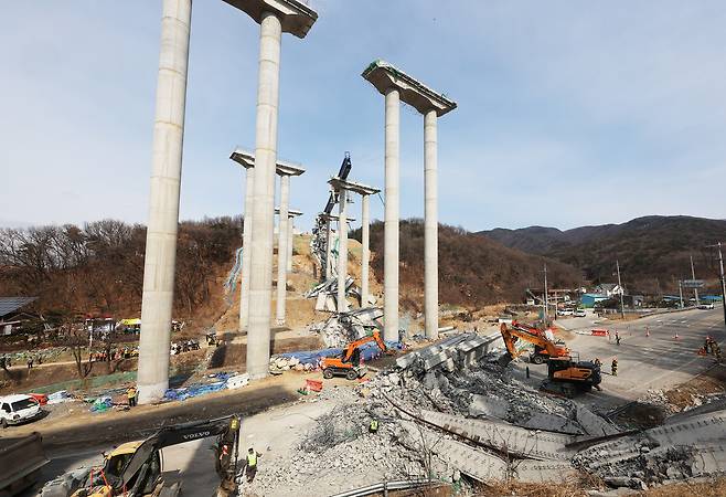 25일 경기도 안성시 서운면 산평리 소재 서울세종고속도로 천안~안성구간 9공구 천용천교 건설 현장에서 교량 연결작업 중 교각에 올려놓았던 상판이 무너지는 사고가 발생해 소방대원들이 인명 수색 구조작업을 하고 있다. [연합]