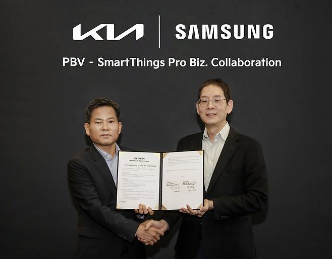 (왼쪽부터)김상대 기아 PBV비즈니스사업부 부사장과 박찬우 삼성전자 B2B통합오퍼링센터 부사장이 기념 촬영을 하고 있는 모습.