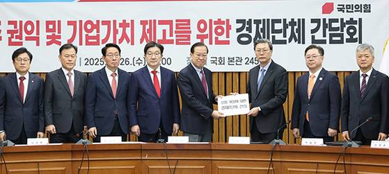 26일 권영세 국민의힘 비 대 위원장(왼쪽 다섯째)이 국회에서 열린 ‘주주권익 및 기업가치 제고를 위한 경제단체 간담회’에서 김창범 한국경제인협회 부회장 으로부터 상법 개정에 대한 경제8단체 건의문을 전달받고 있다. 상법 개정안은 이사의 충실 의무 대상을 주주로 확대하는 내용이다. [연합뉴스]