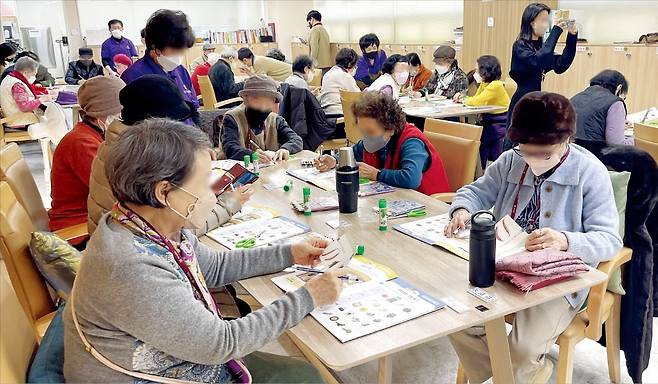 지난달 28일 경기 성남시 구미동 대교뉴이프 데이케어센터 분당센터를 찾은 노인들이 요양보호사의 지도에 따라 미술 수업을 듣고 있다.  황정환 기자