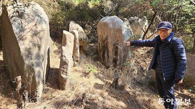 지난달 28일 옥숙표 씨(79)가 부산 해운대구 장산의 바위를 손가락으로 가리키고 있다. 옥 씨는 “누군가 의도적으로 세워놓은 듯한 바위들이 일정한 간격으로 배치돼 있는 만큼 역사적 가치를 확인하는 전문가 조사가 이뤄져야 한다”고 주장했다. 김화영 기자 run@donga.com