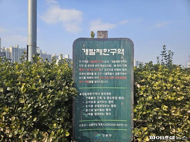 강동구 개발제한구역 안내 표지판 뒤로 늘어선 아파트 단지가 보인다. 사진=최가영 기자