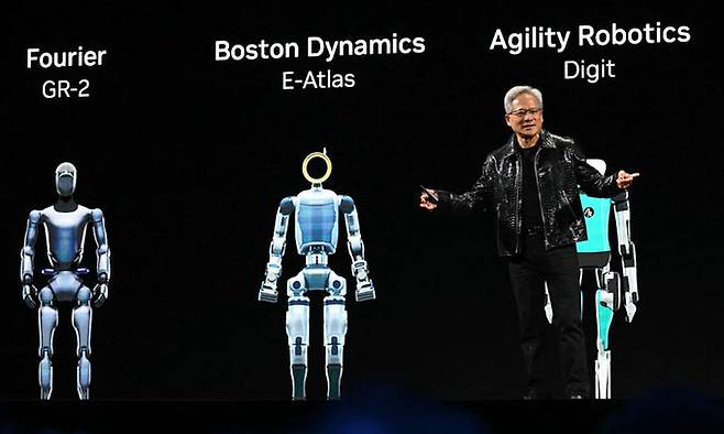 젠슨 황 엔비디아 최고경영자(CEO)가 지난 1월 6일(현지시간) 미국 네바다주 라스베이거스에서 진행된 ‘CES 2025’ 키노트 행사에서 인공지능(AI) 개발 플랫폼 ‘엔비디아 코스모스’와 코스모스가 적용된 휴머노이드 로봇들을 소개하고 있다. [사진출처 = 연합뉴스]