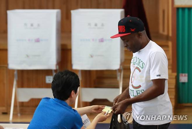 한국에서의 두 번째 투표 (서울=연합뉴스) 홍해인 기자 = 2018년 6월 13일 서울 용산구 이태원초등학교 교육문화관에 마련된 지방선거 투표소에서 나이지리아 출신의 공장 노동자 우구오마 오빈나 사무엘(52) 씨가 선거인명부를 확인하고 있다. 한국 영주권을 받은지 3년이 경과하고 자치단체의 외국인등록대장에 등재된 외국인은 선거에서 투표권을 행사할 수 있다. [연합뉴스 자료사진] 2026.3.5