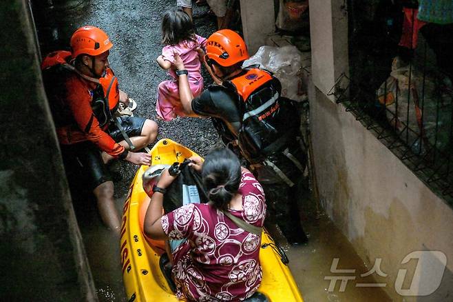 4일(현지시간) 자카르타 파사르 밍구 지역에서 구조대원들이 침수피해를 입은 사람들을 대피시키고 있다. 2025.3.6 ⓒ AFP=뉴스1