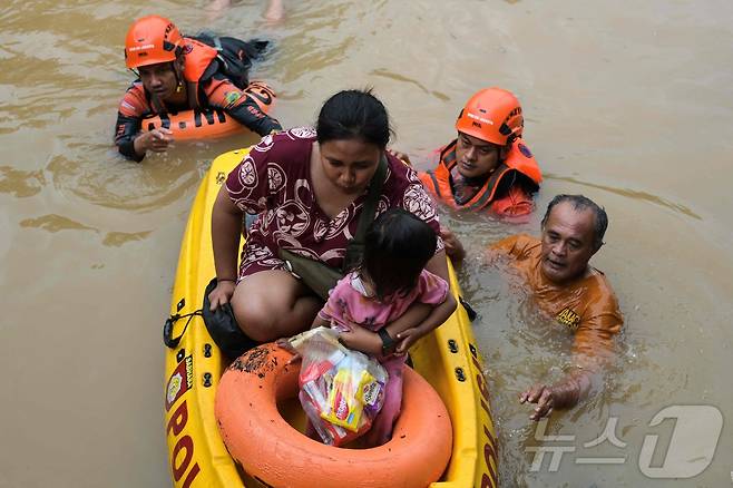 4일(현지시간) 자카르타 파사르 밍구 지역에서 구조대원들이 침수피해를 입은 사람들을 대피시키고 있다. 2025.3.6 ⓒ AFP=뉴스1