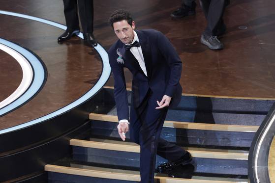 할리우드 배우 애드리언 브로디가 아카데미 시상식 남우주연상을 받기 직전 씹던 껌을 뱉어 여자친구 조지나 채프먼에게 던지는 모습. EPA=연합뉴스