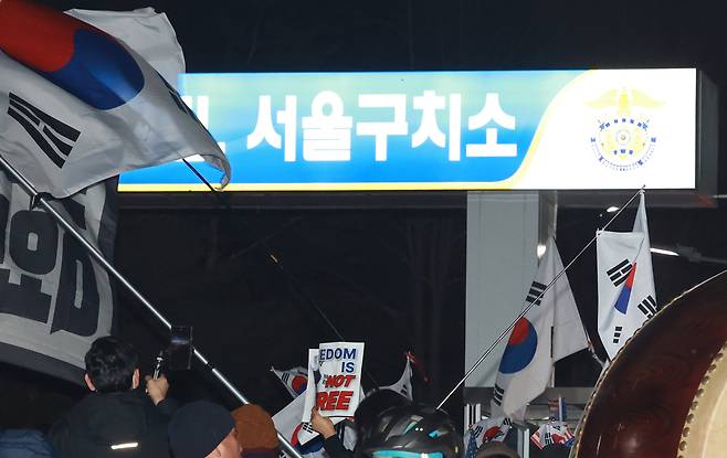 법원이 윤석열 대통령의 구속 취소 청구를 받아들인 7일 경기도 의왕시 서울구치소 앞에서 윤 대통령 지지자들이 구호를 외치고 있다.    연합뉴스